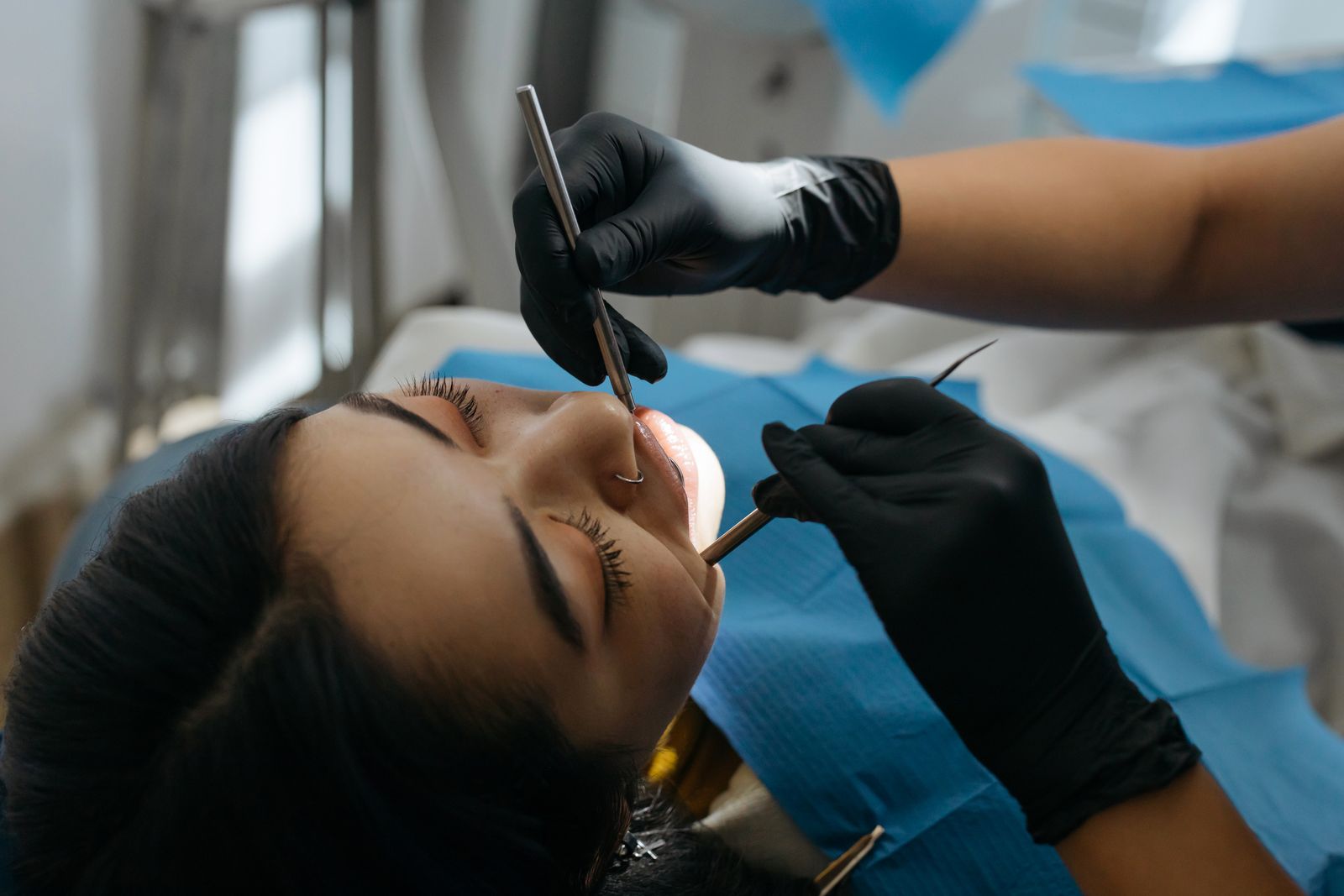 A dentist examining a patient's teeth up close, the kind of check that finds the source of a bad taste from a tooth