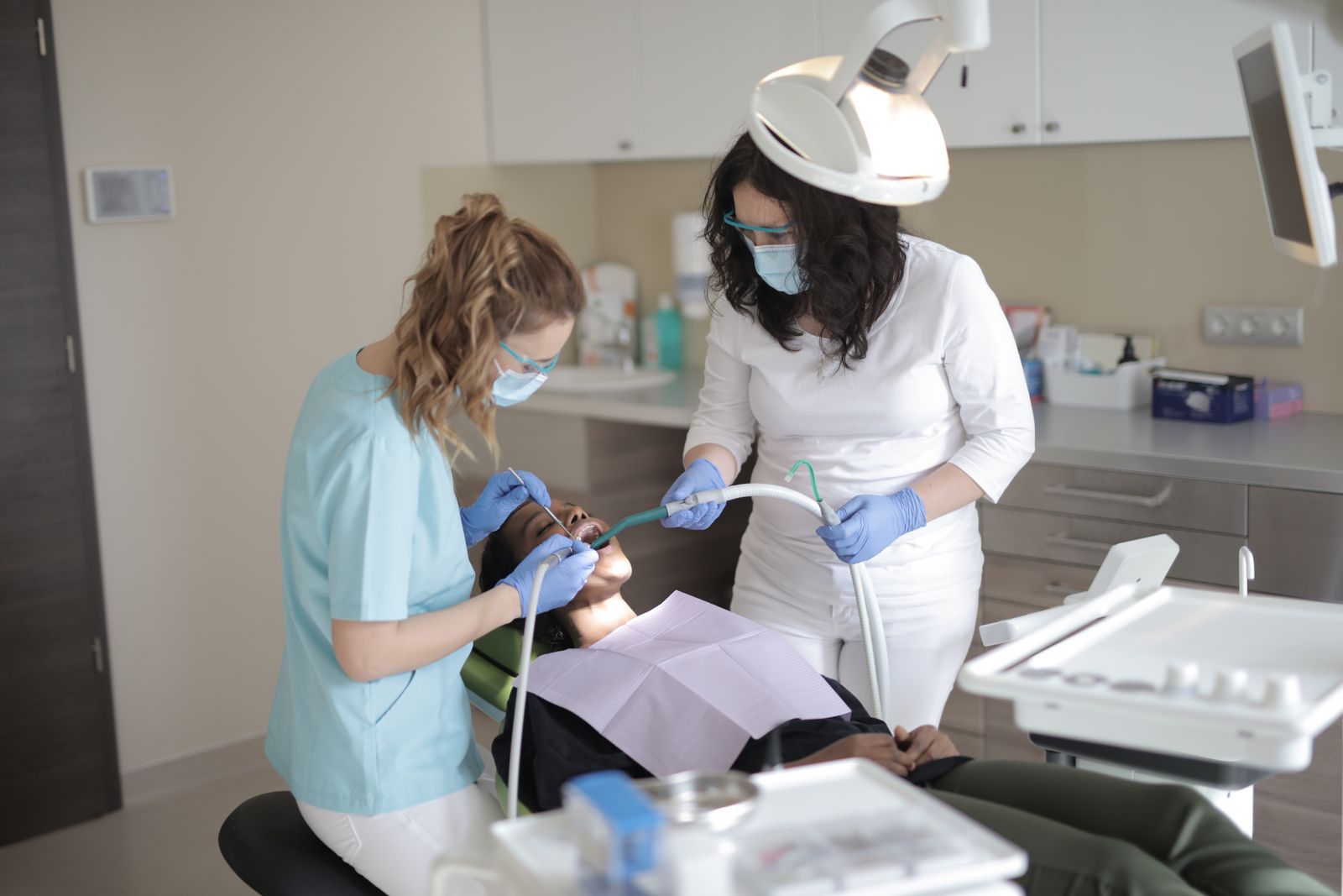 A dentist examining a patient's teeth to decide between a filling and a crown