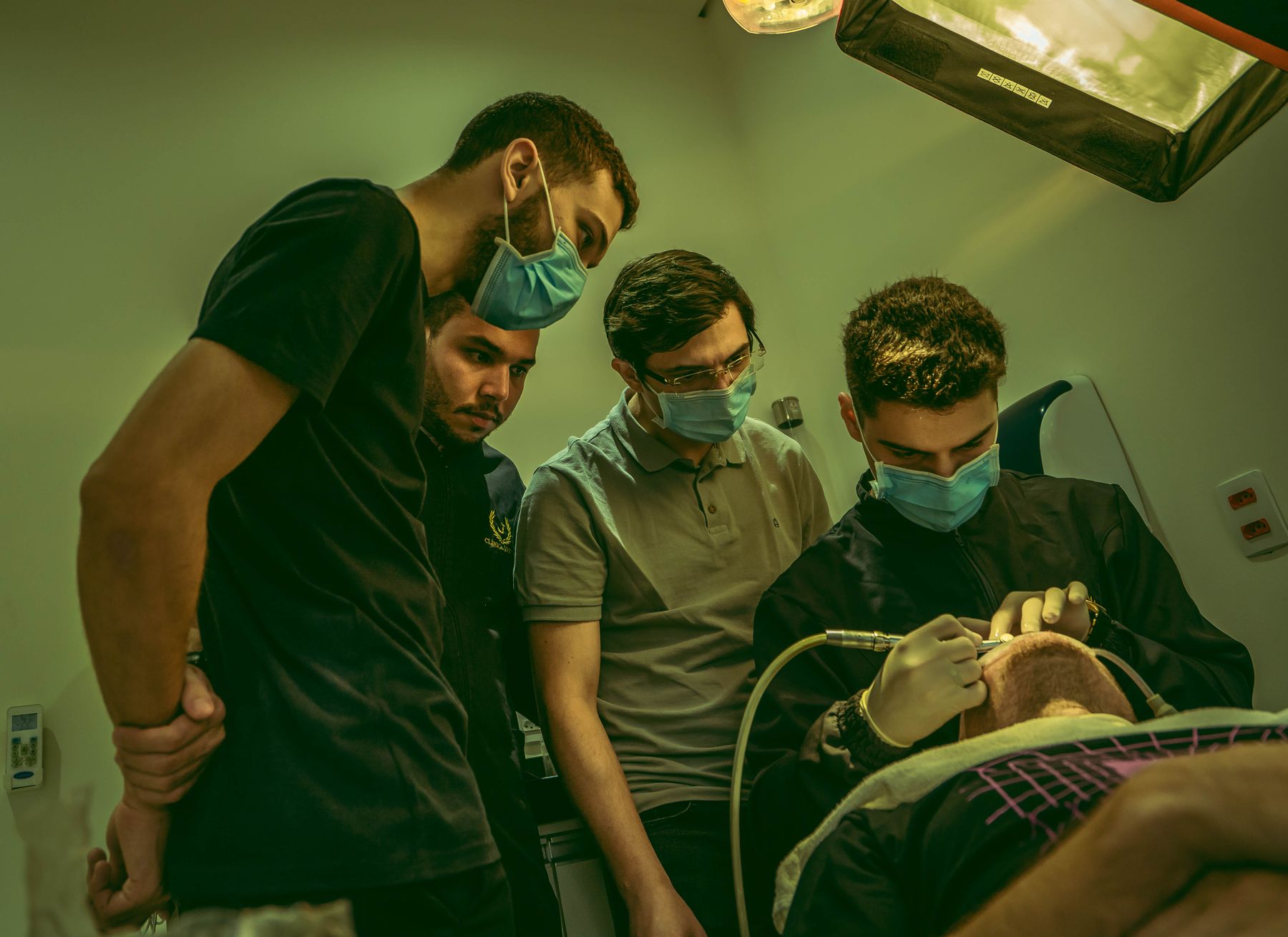 רופא שיניים וצוות מבצעים טיפול משותף ומפוקח במרפאה