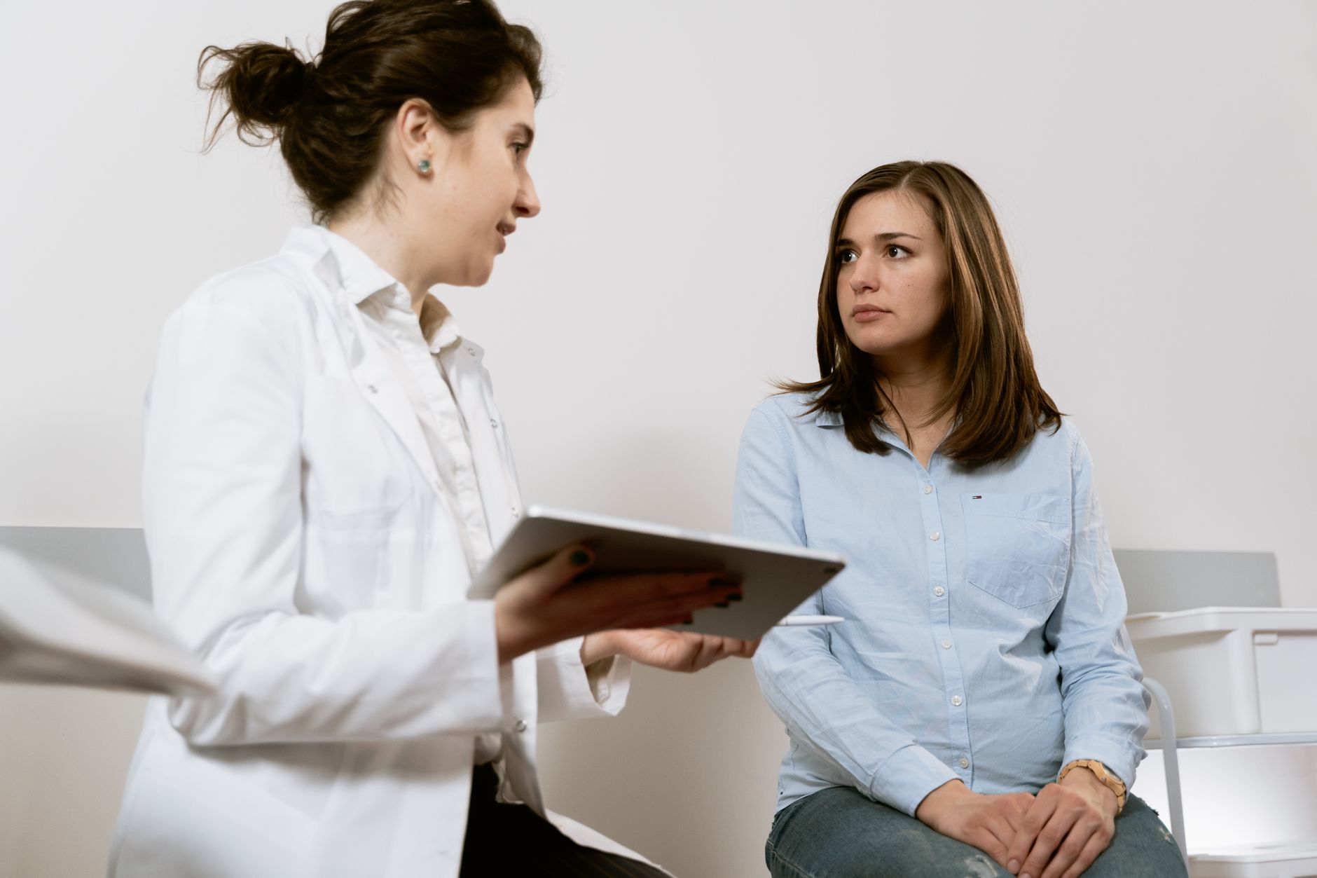 A pregnant patient talking with a doctor during a consultation