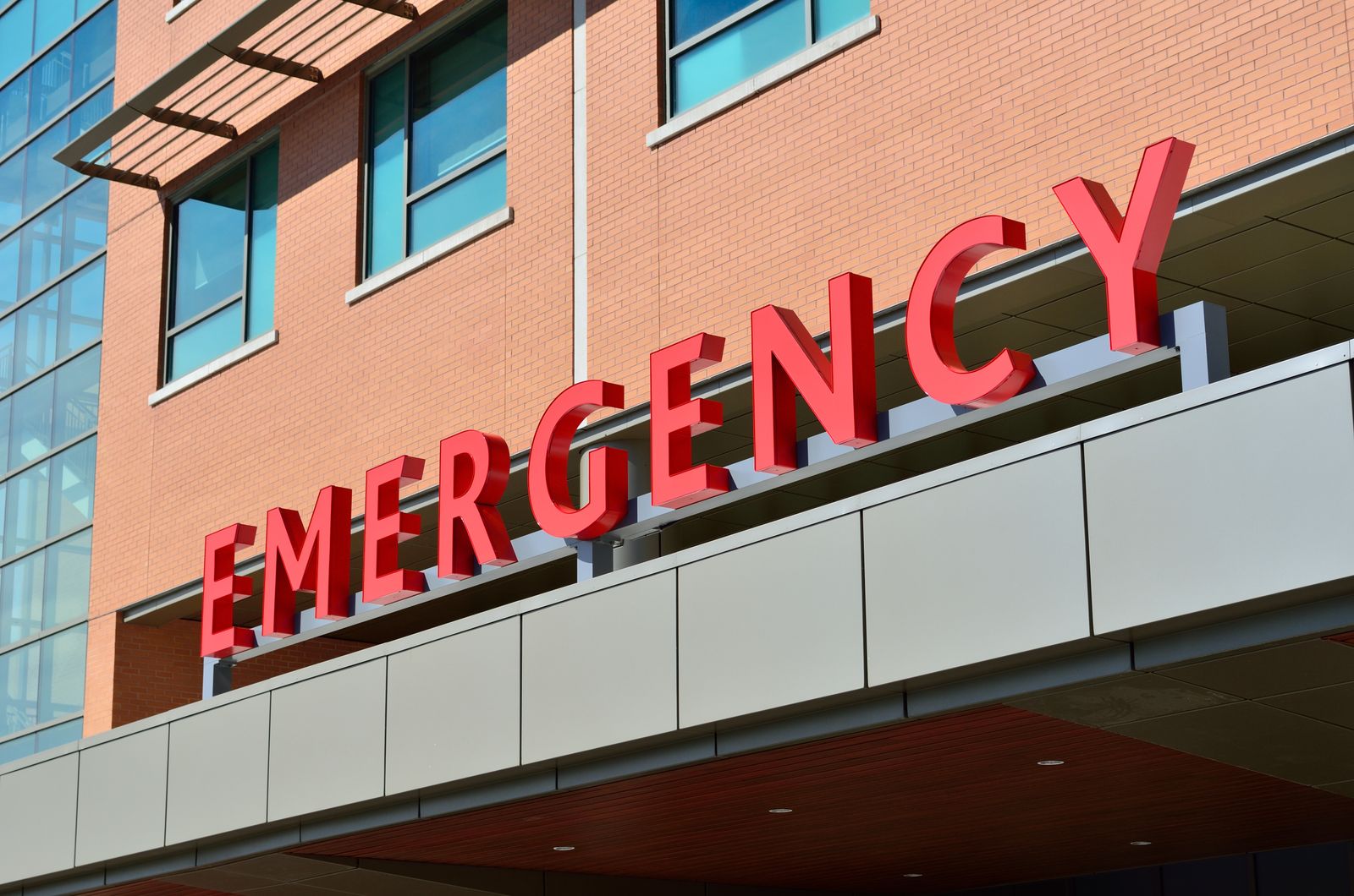 Red emergency department sign above the entrance to a hospital at night