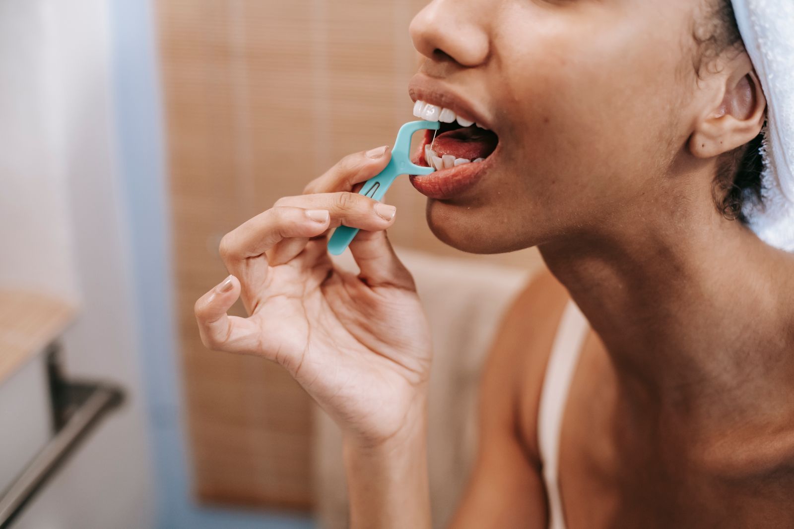 Close-up of a person flossing between their teeth