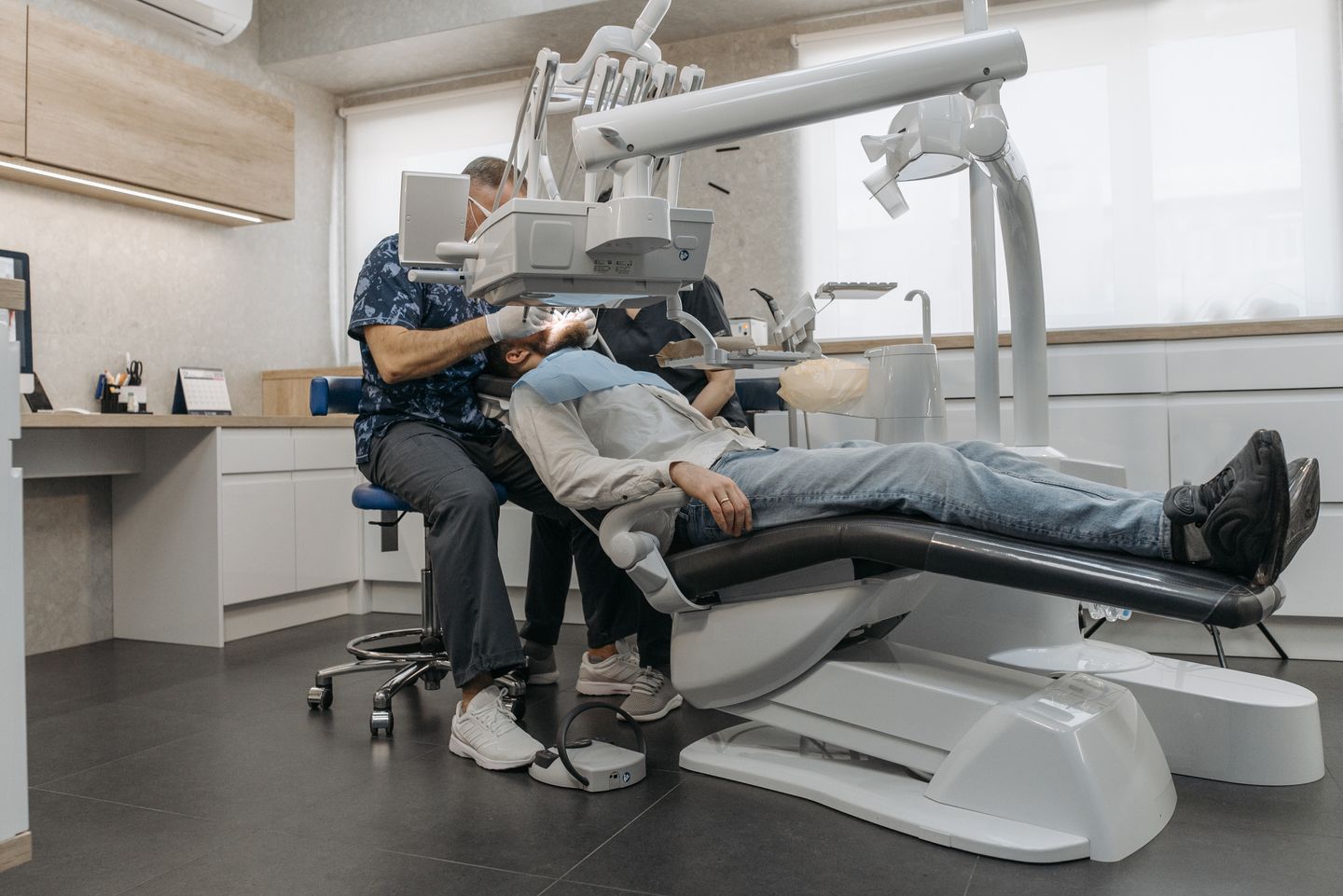 A dentist checking a patient's teeth after dental treatment