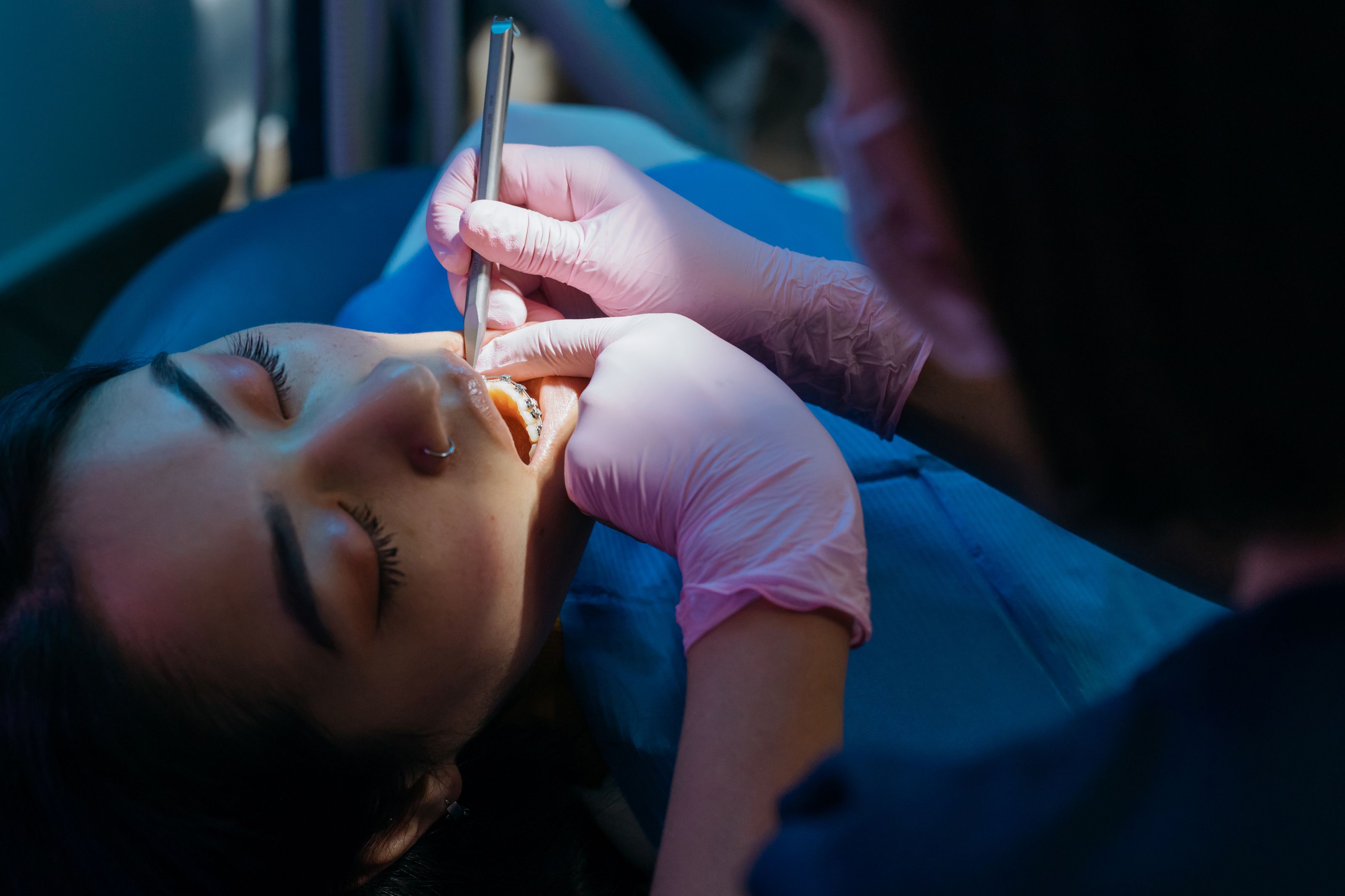 A dentist examining a patient's tooth during a visit for a recurring root canal problem