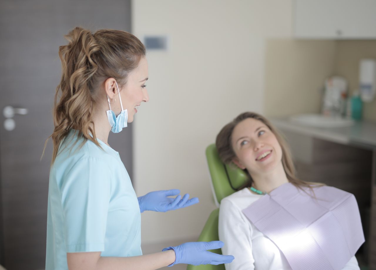 A dentist in conversation with a patient during an appointment