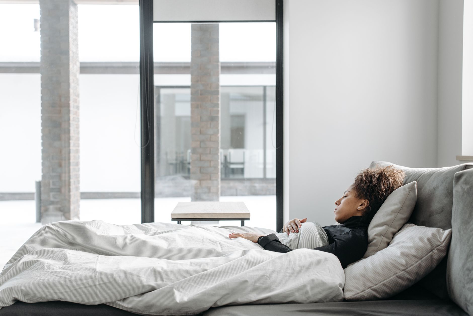 A woman resting comfortably on a sofa at home while recovering