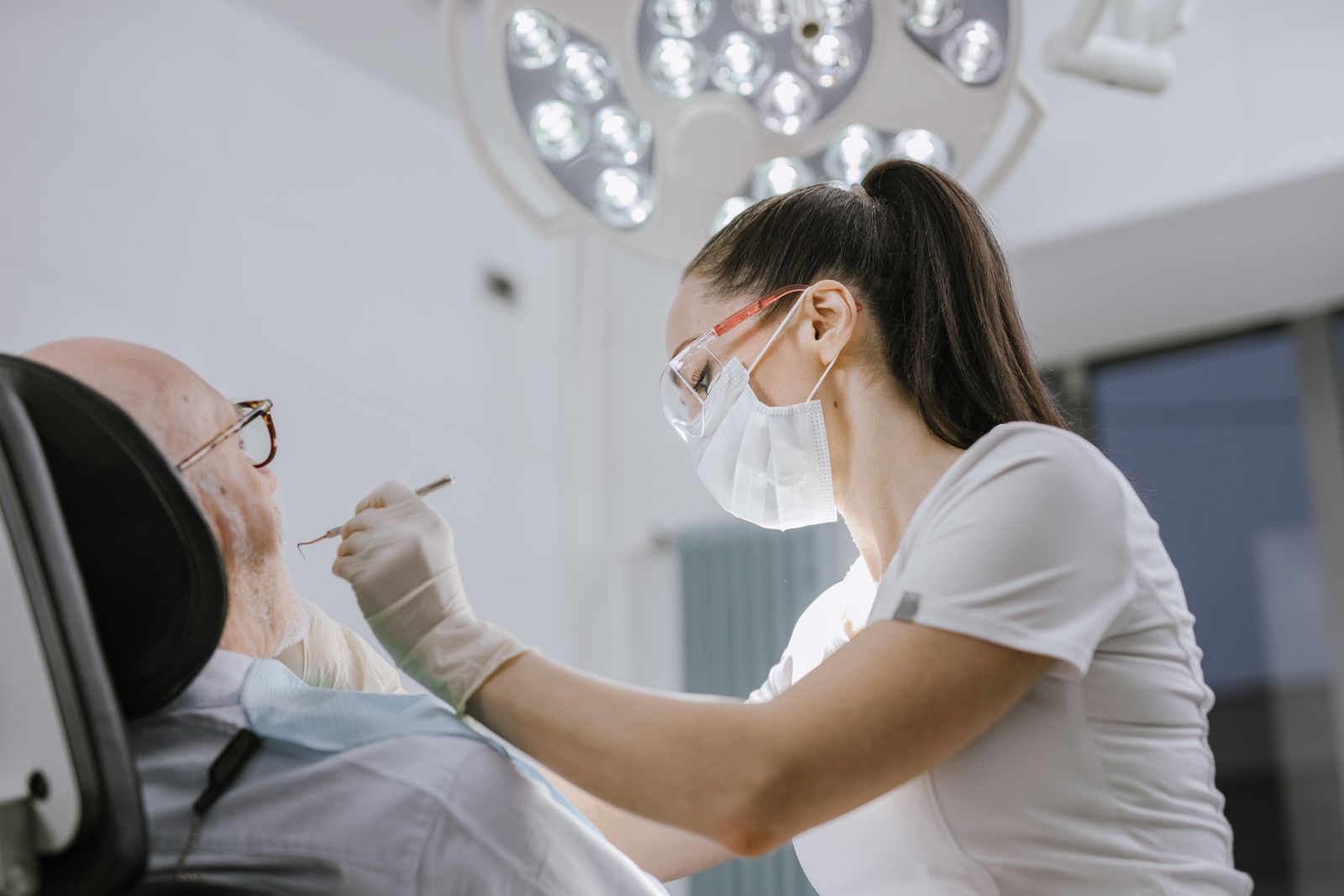 A dentist examining a patient's teeth during a visit for a tooth abscess