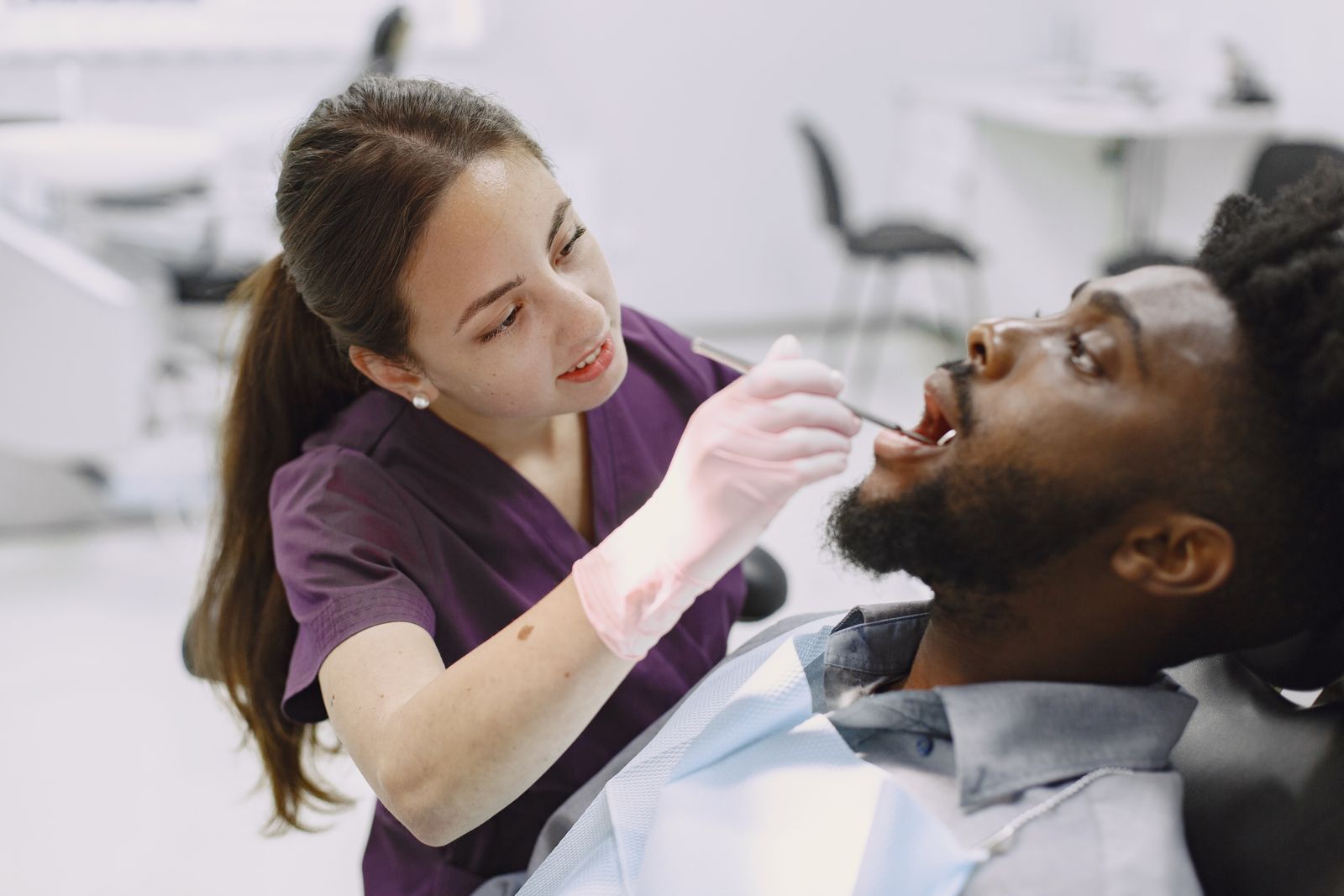 A dentist checking a patient's teeth during an examination