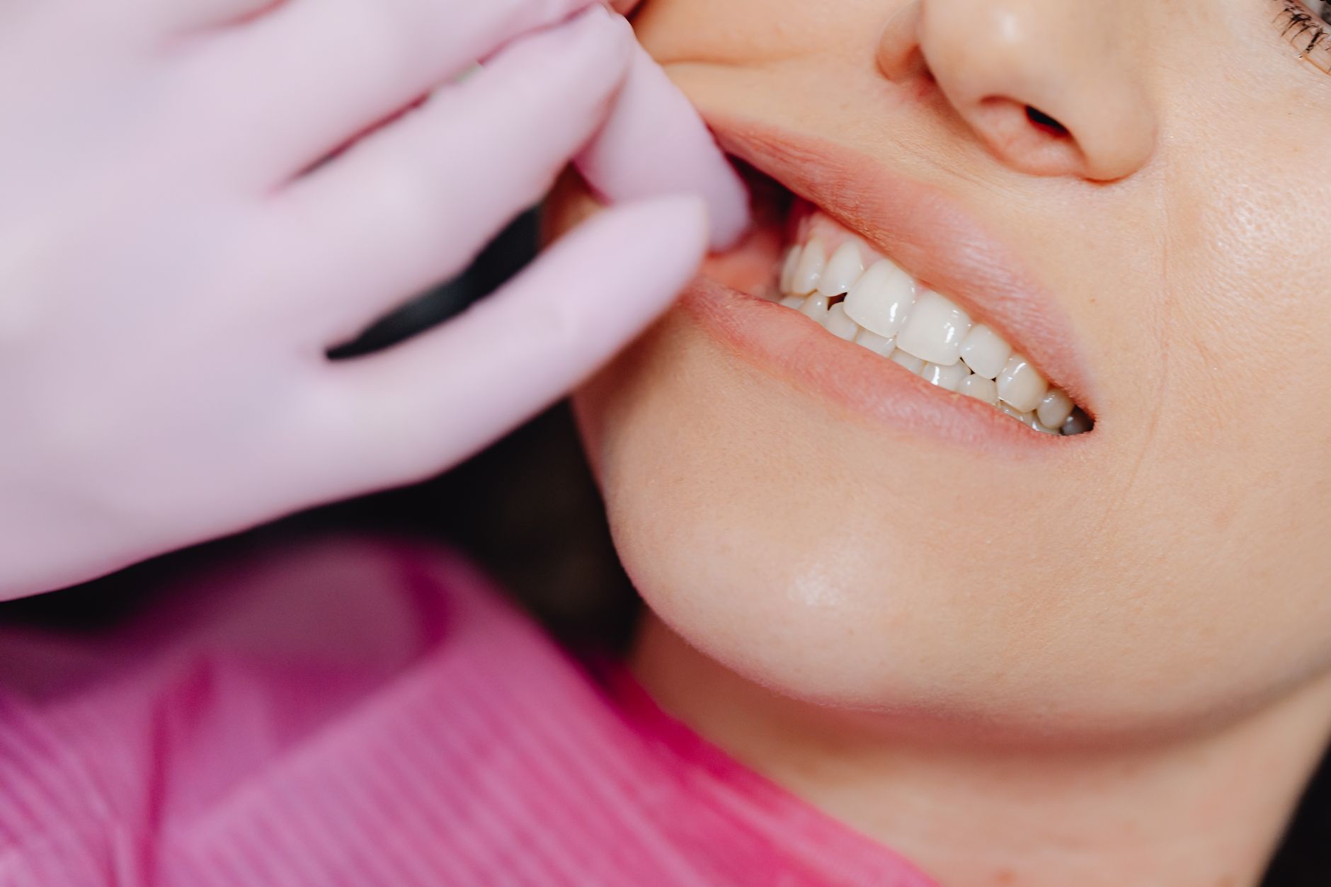 A dentist gently holding back a patient's lip to check how the teeth meet