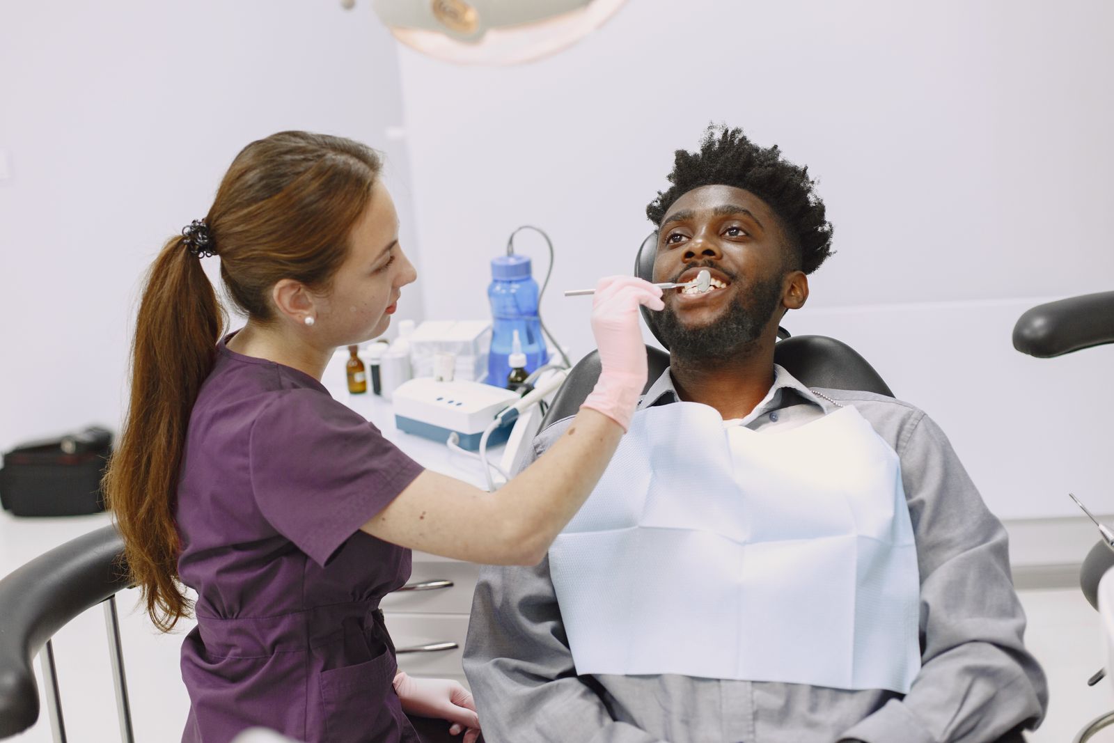 A patient in the dental chair having a tooth checked, the kind of visit that settles pain after a new crown