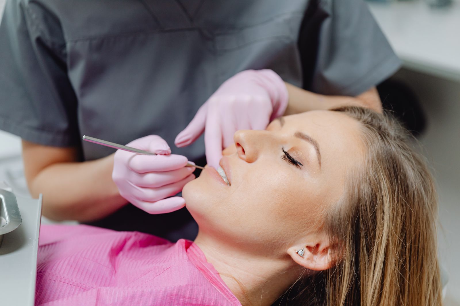 A woman having her teeth examined by a dentist, the kind of check that finds why a tooth has turned grey