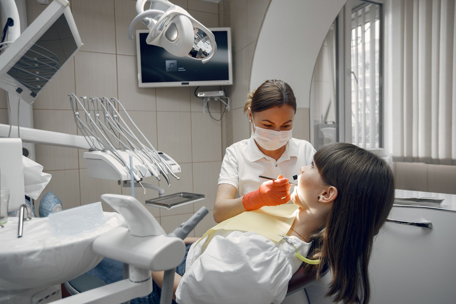 A dentist treating a patient's tooth in a bright clinic