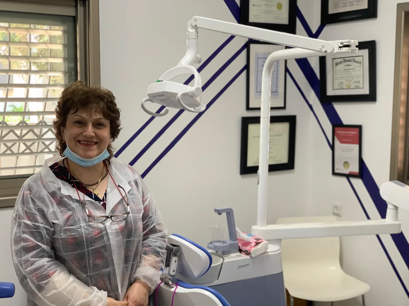 חדר טיפולים במרפאה בבית שמש, עם כיסא טיפולים ותעודות ממוסגרות על הקיר.